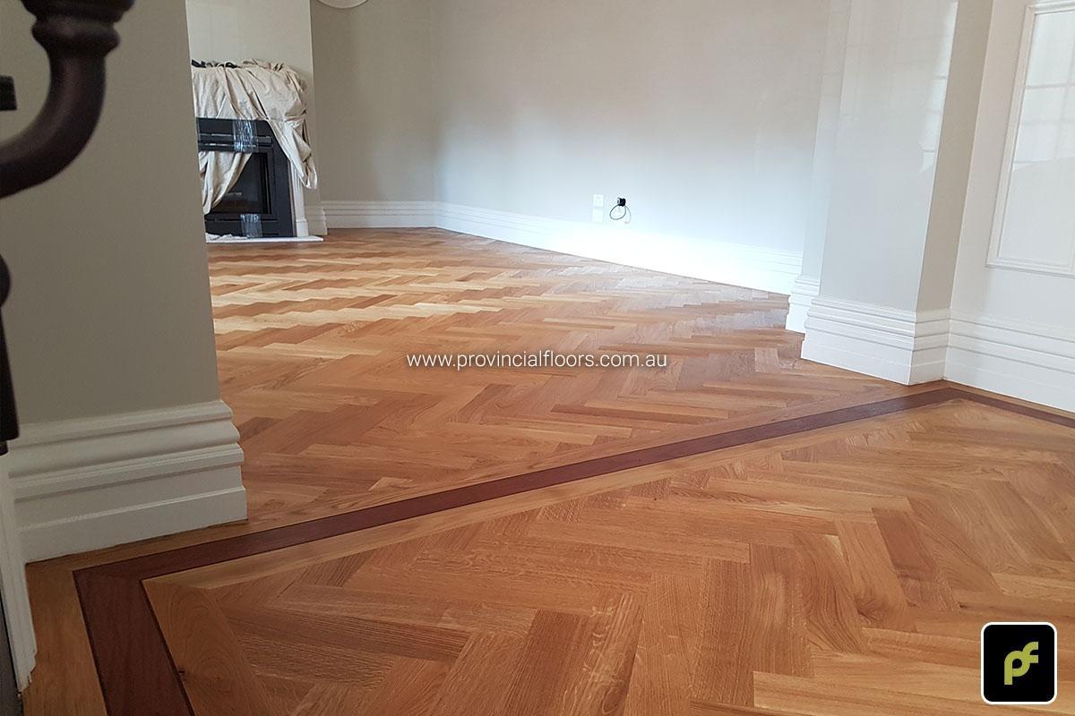 European Oak Herringbone Parquetry with a Jarrah border design feature. With a Natural Coloured Oil/Wax Finish. Matte in sheen and easily repairable.