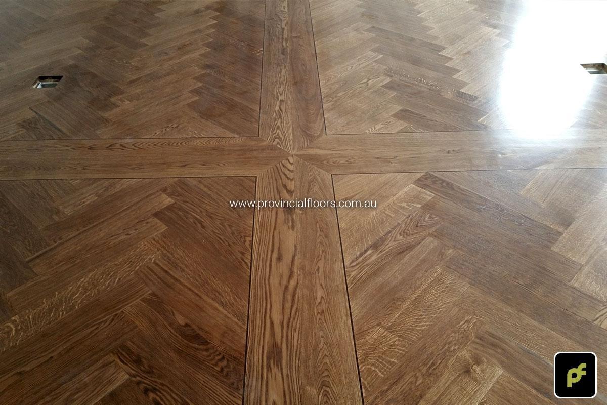 European Oak Herringbone Parquetry with a quadrant border design. With a Stained Water-Based Polyurethane Finish. Satin in sheen.