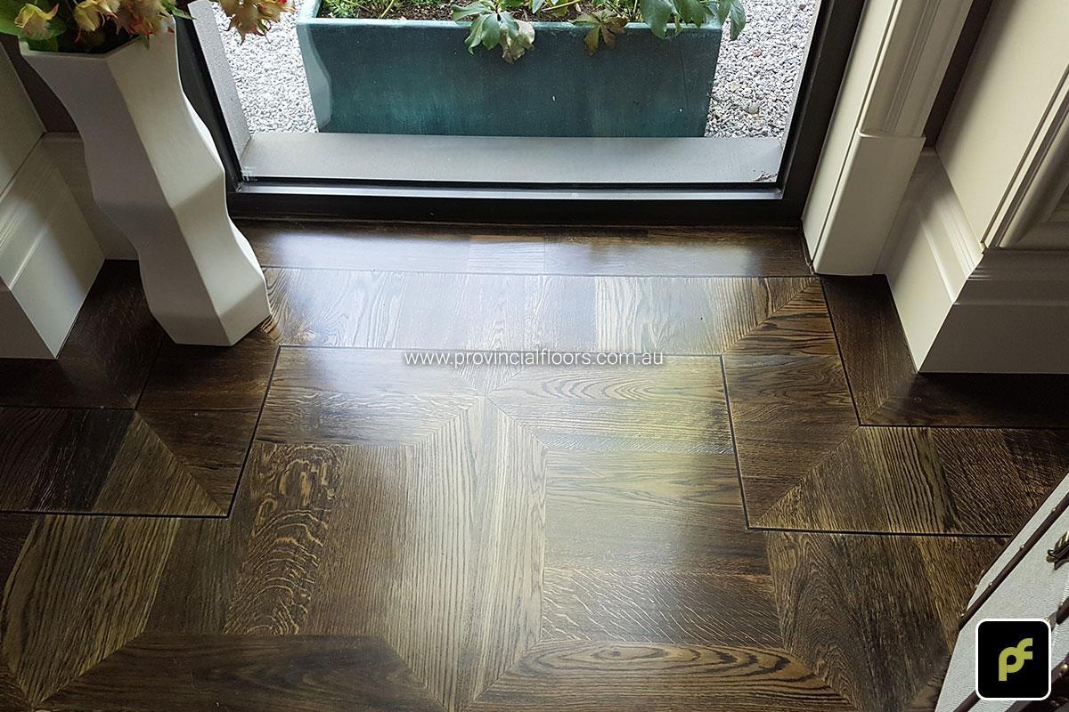 American Oak hand-made Monticello Paneled Parquetry with circumnavigating border designs. With a Stained Water-Based Polyurethane Finish. Satin in sheen.