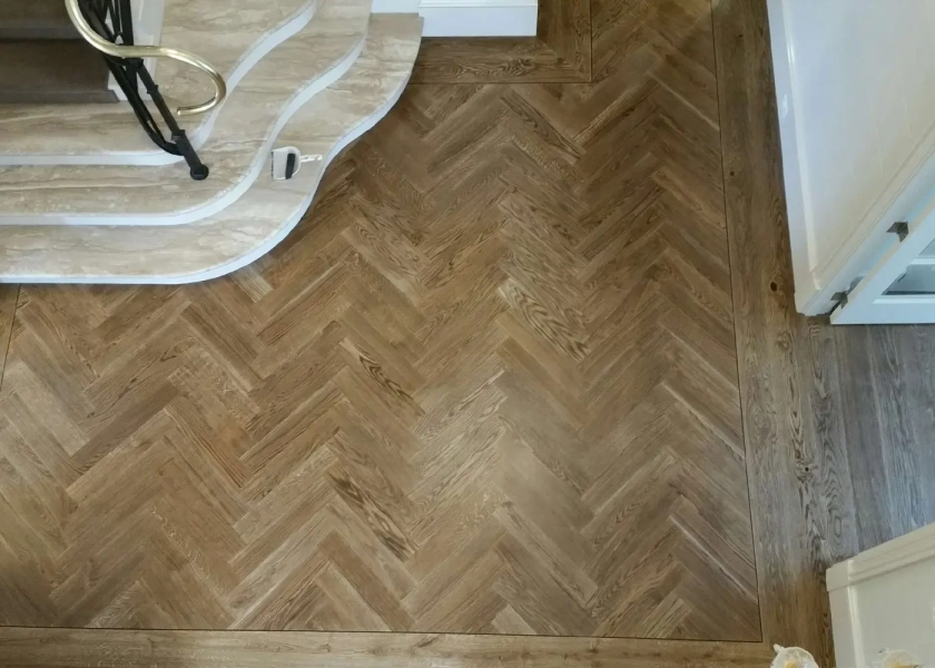 European Oak Herringbone Parquetry Flooring with a quadrant border design. With a Stained Waterbased Coating. Satin in sheen - Birds Eye