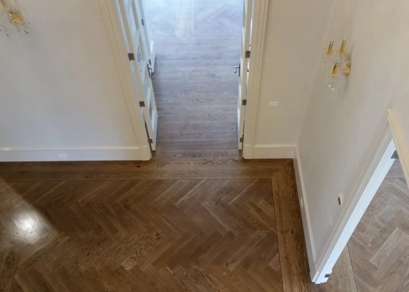 European Oak Herringbone Flooring with a quadrant border design. With a Stained Waterbased Coating. Satin in sheen - Birds Eye Passage